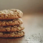Freshly baked peanut butter oatmeal cookies stacked on rustic table